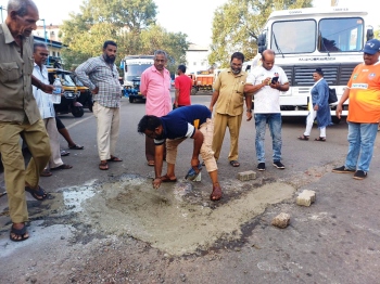 Rickshaw drivers repair pothole near bus stand